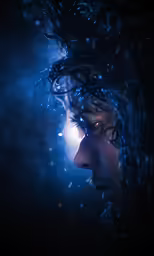 a young man stares out into the distance through a flowing light source