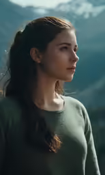 a beautiful woman in a green sweater looking off into the distance