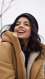 an asian woman smiling and wearing a hooded coat