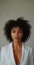 a close up of a woman in a suit posing for a photo