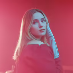 a woman holding a phone and looking off into the distance