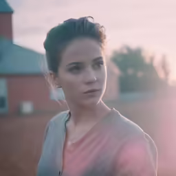 an attractive young woman standing outside in the evening