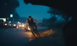a man riding a bicycle down a street at night