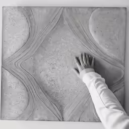 a person reaches down to touch a wall with their hand