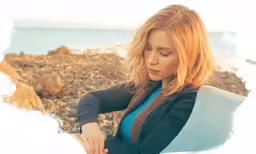 a woman is sitting down looking at something