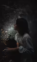 a woman sits alone, gazing out at the stars