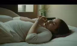 a pregnant woman laying on top of a bed