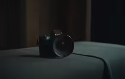 a camera sitting on top of a green pillow