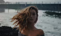 a woman in front of a body of water