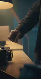 a man points to the camera as it sits on a desk