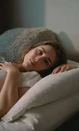 a young woman laying down on top of a bed