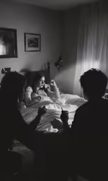 black and white photo of woman in bed with cat