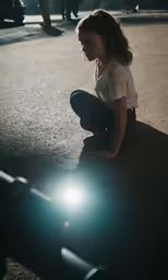 a woman is crouched down looking at the ground