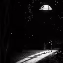 a young person walks under an umbrella in the dark