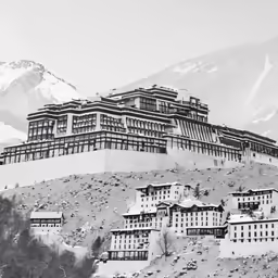 a large building on a hill, surrounded by trees