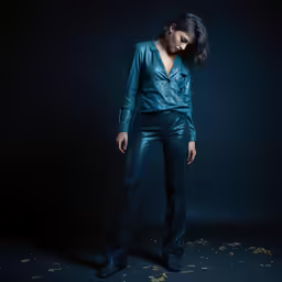 a woman in a blue top and metallic pants