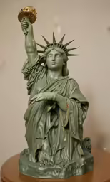 a statue with green leaves on its head holding a golden crown