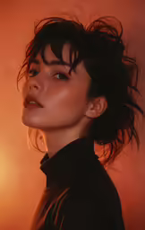 a woman with black hair and a ponytail looking off into the distance