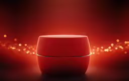 the red speaker sits in front of a glowing boke of lights