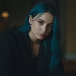 the woman is sitting down looking at the camera