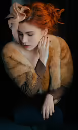 a woman with red hair in a fur jacket