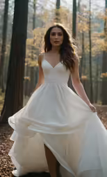 a woman in a white dress posing in the woods