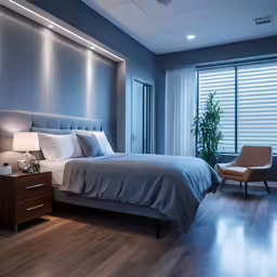 an illuminated bedroom contains a bed with an oversized headboard and low lighting