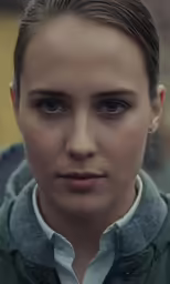 the woman is looking towards the camera with serious look