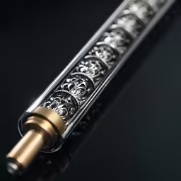 a gold colored pipe sits on the black surface