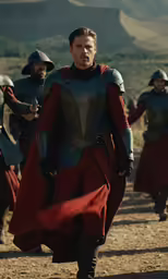 the man in armor is walking in front of several men