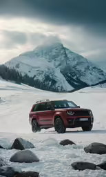 a small orange car is driving through the snow