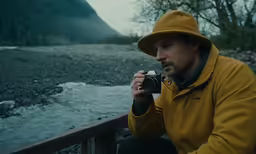 a man taking a photo of a river