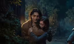 a man hugs his friend from behind in the woods