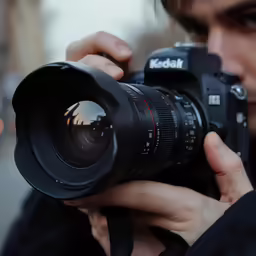the person is holding a camera up to take pictures