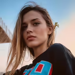 a woman in a black shirt is standing on the beach