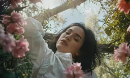 the woman is looking at flowers in the background