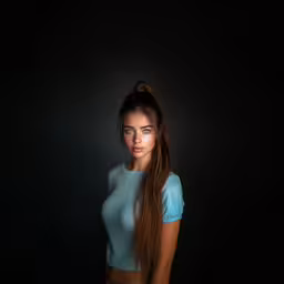 a girl posing in front of a black background,the young woman with long hair is posing for the camera