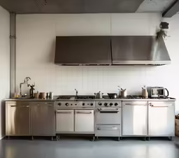 a kitchen has an oven, range and hood