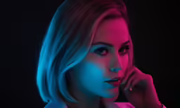 a beautiful blond woman is photographed in a neon colored light