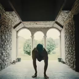 a woman wearing sandals is stretching in an archway