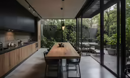 the open plan kitchen is located behind a glass enclosed courtyard