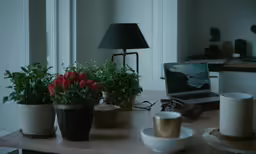a laptop sits on a table with flowers in the center
