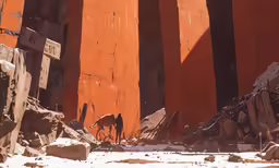 an animal walking between large columns near a rocky beach