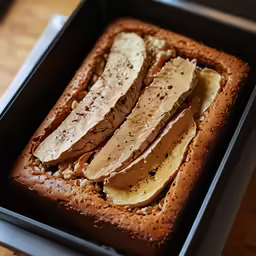 bread with bananas in a pan sitting on a table