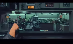 a person is sitting near a machine in a large factory