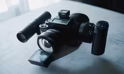 a camera with its lens and a tripod next to it