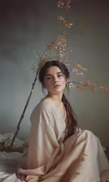 an image of a woman sitting on the ground with a tree growing from her head