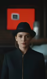 a woman wearing black is looking directly into the camera