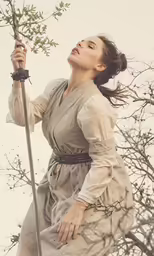 woman holding onto a tree with a spear