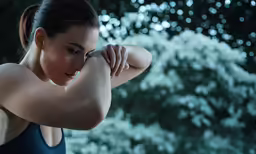 a woman with her arm crossed holding her hand near her head